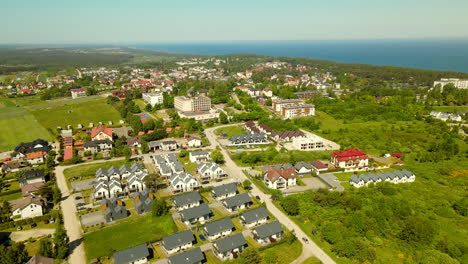 Aerial-flyover-polish-coast-city-named-Jastrzebia-Gora-during-sunlight-and-green-farm-fields
