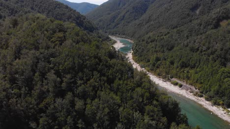 Drone-flight-over-beautiful-forest-valley-flowing-river-scenery-on-clear-sunny-day-in-4K