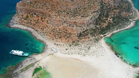 Aerial-Balos-Twin-Beach-and-Lagoon-with-turquoise-water,-mountains-and-cliffs-in-Crete,-Greece