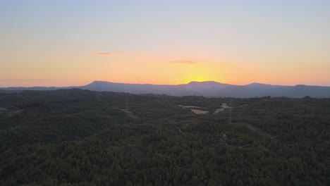 Luftaufnahmen-Eines-Sonnenuntergangs-Mit-Den-Bergen-Und-Windmühlen-Im-Hintergrund