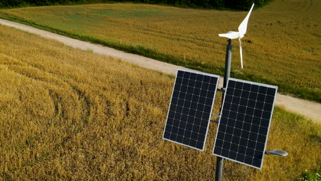 Luftbild-Von-Sonnenkollektoren-Und-Kleinen-Windkraftanlagen,-Die-Auf-Dem-Feld-Des-Bauernhofs-Im-Sonnenlicht-Installiert-Sind