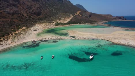 Drone-flying-over-Balos-Beach-and-Lagoon-with-turquoise-water,-mountains-and-cliffs-in-Crete,-Greece