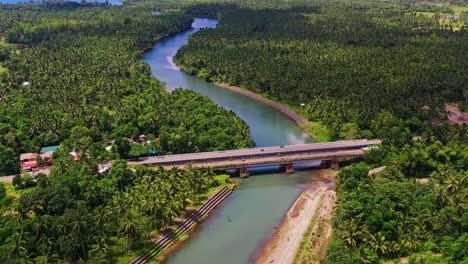 Aerial-View-Of-A-Bridge-Over-Flowing-River-Among-Thicket-Woods-In-Saint-Bernard,-Southern-Leyte-in-the-Philippines