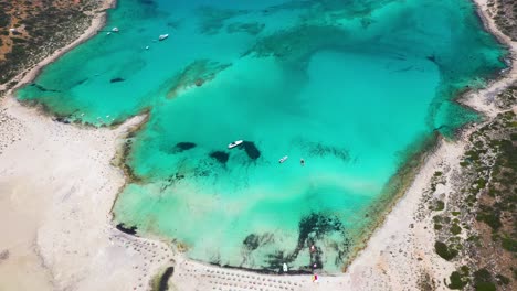 Aerial-top-down-spinning-overBalos-Beach-and-Lagoon-with-turquoise-water,-mountains-and-cliffs-in-Crete,-Greece