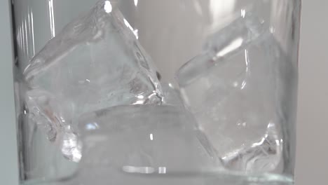 Makro-Eiswürfel-In-Der-Klaren-Hohen-Klasse-Haben-Eine-Klare-Flüssigkeit,-Die-In-Zeitlupe-4k-Gegossen-Wird