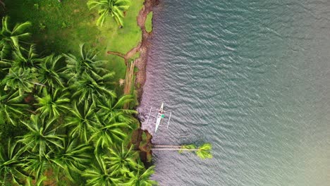 Outrigger-Boat-On-Rivershore-With-Dense-Palm-Trees-In-Tropical-Forest-Near-Saint-Bernard,-Southern-Leyte-in-the-Philippines