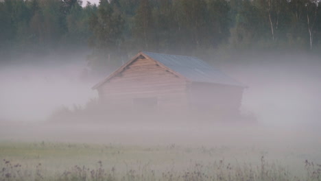 Rustic-Old-rural-barn-in-moving-Mist-and-Fog-in-scenic-deserted-farmland