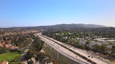 Rising-Aerial-Over-Busy-Freeway-Traffic-and-Sunny-Clear-Blue-Sky,-San-Diego,-California