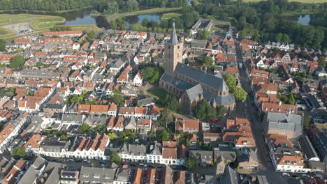 Drone-flying-away-from-beautiful-large-church-in-the-city-center-of-Naarden,-an-old-fortress-town-in-the-Netherlands