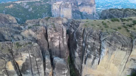 Flying-slowly-and-close-over-Sandstone-canyon-in-Meteora,-Greece,-aerial