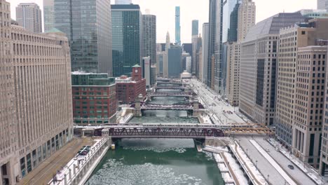 Aerial-Descending-Shot-Above-Chicago-River---Subway-Train-Crossing-Bridge-to-Enter-Loop