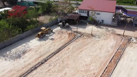 drone-shot-tractor-digging-land-for-apartment-project