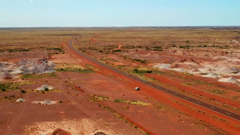 View-Of-A-Car-On-Red-Desert-By-The-Highway-Of-Stuart-In-Northern-Territory,-New-South-Wales,-Australia
