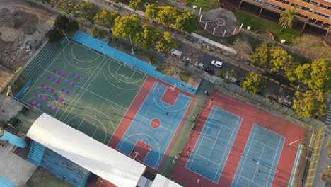 Aerial-top-down-shot-of-players-playing-basketball-on-court-during-sunny-day,4k