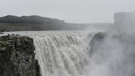 Tourists-look-on-at-the-immense-power-of-the-Dettifoss-waterfall-in-Iceland