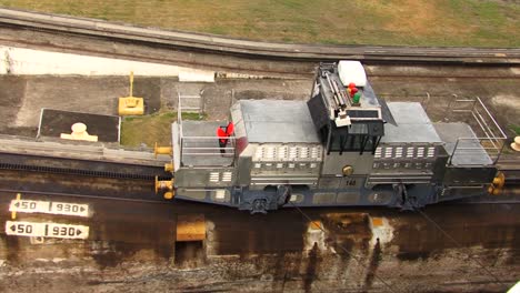 Electric-locomotive-starting-slowly-to-pull-the-ship-at-Panama-Canal,-Gatun-Locks
