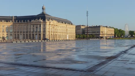 Bordeaux-Wasserspiegel-Bei-Sonnenaufgang-Mit-Platz-De-La-Bourse-Dahinter-Mit-Reflexionen-Und-Morgensonne