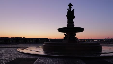 Fountain-of-the-three-graces-in-bordeaux-at-dawn-with-tramway-behind-and-sun-rising