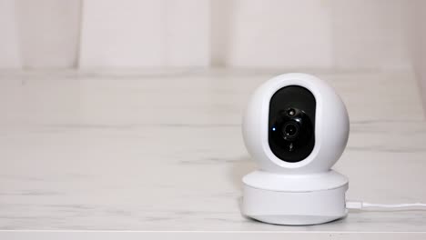 Indoor-CCTV-wireless-IP-security-camera-with-360-degrees-rotating-head,-Concept-of-home-security-system-for-surveillance-and-protection,-controlling-via-smartphone-online