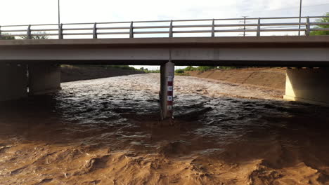 Escala-De-Medición-De-Agua-Inundada-En-Un-Río-Embravecido-Debajo-Del-Puente