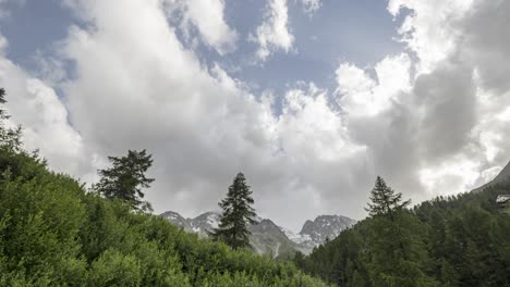 Zeitraffer-Von-Sich-Schnell-Bewegenden-Wolken-über-Einem-Alpinen-Waldtal-Mit-Berggipfeln-Im-Hintergrund