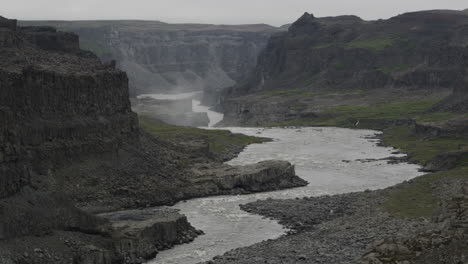 The-harsh-terrain-and-powerful-river-Jokulsa-a-Fjollum-below-Dettifoss-falls---Icelands-barren-and-forebodinglandscape