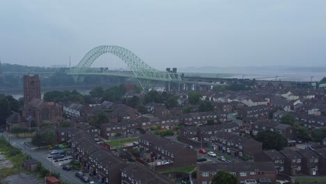 British-Northern-Runcorn-bridge-backdrop-of-suburban-residential-townhouse-neighbourhood-aerial-view-slow-right-dolly