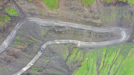 Downward-angle-drone-shot-of-vehicle-driving-on-the-Road-to-Tusheti,-one-of-the-worlds-most-dangerous-roads