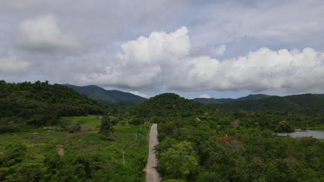 A-reverse-aerial-footage-revealing-the-road-going-in-Kaeng-Krachan-National-Park,-UNESCO-World-Heritage-site,-Thailand,-and-such-a-beautiful-place-to-be-at-watching-birds-and-animals
