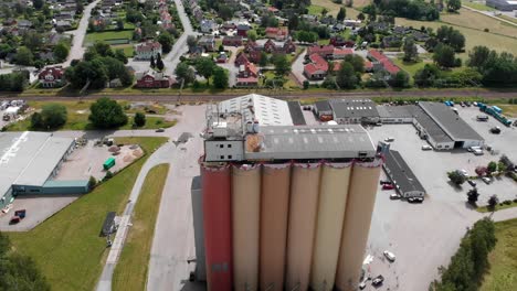 AERIAL---A-grain-silo-in-Bralanda,-Vanersborg,-Sweden,-wide-shot-forward-top-down