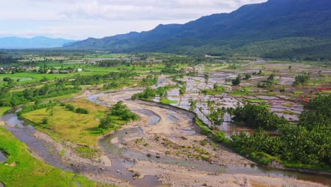 Panorama-De-Los-Arrozales-Después-De-La-Cosecha-Inundados-Con-Agua-Cerca-Del-área-De-Trituración-De-Piedra-De-Cantera-En-El-Sur-De-Leyte,-Filipinas