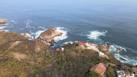 Pull-front-and-view-of-Puerto-Angel's-small-lighthouse-and-cliffs-in-Oaxaca's-rocky-shore