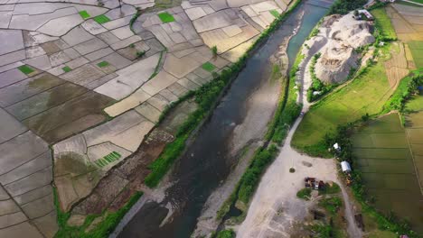 Stream-Flowing-Among-Paddy-Fields-Near-The-Quarry-Stone-Crusher-Plant-In-Southern-Leyte,-Philippines