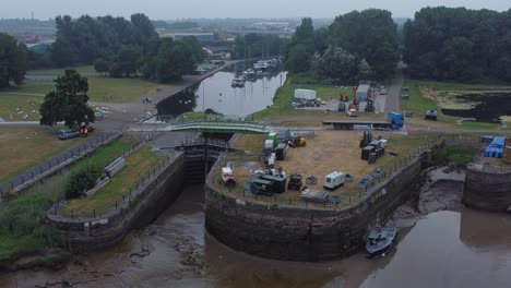 Aerial-view-Spike-island-council-workers-removing-Resurrection-concert-barriers-from-river-canal-park-low-left-dolly