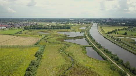 Vista-Aérea-De-Drones-Del-Hermoso-Canal-Maxima-Y-El-Paisaje-Verde-En-Los-Países-Bajos-De-Europa