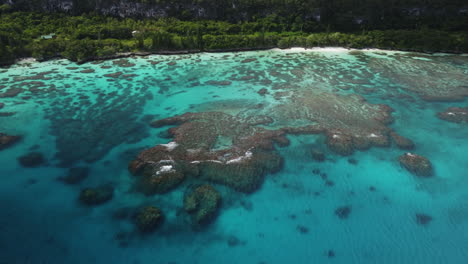 Aerial-tracking-view-of-Maré-Island-coastline,-coral-reef-in-Loyalty-Islands