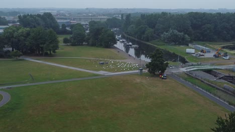 Aerial-view-Spike-island-council-workers-removing-Resurrection-concert-barriers-from-river-canal-park-slow-right-pan