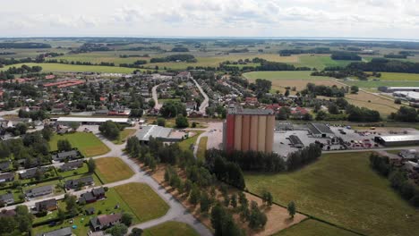 Aerial-dolly-out-landscape-shot-of-Lantmännen-Lantbruk-agribusiness-industrial-structure-of-farm-grain-silos-for-agriculture-crops-storage-in-rural-Brålanda-town-Sweden