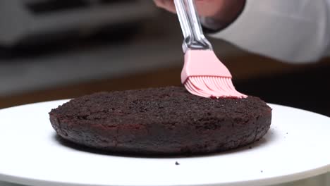 spreading-rose-water-on-cake-making-process