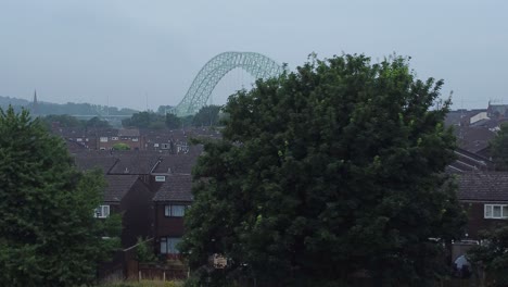 Rising-reveal-above-British-Northern-Runcorn-bridge-suburban-residential-townhouse-neighbourhood-aerial-view