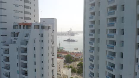 Aerial-Establishing-Shot-of-Unmarked-Naval-Gunboat-Framed-Between-Skyscrapers