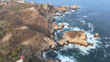 Pull-back-and-view-of-cliffs-and-Puerto-Angel's-small-lighthouse-in-Oaxaca's-rocky-shore