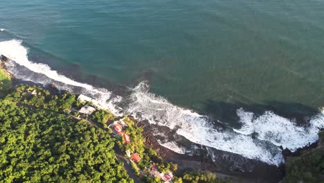 Aerial-shot-of-ocean-waves-crashing-the-coastline,-El-Tunco-beach-in-El-Salvador,-tourism-and-surfing