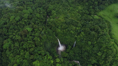 Orbiting-aerial-around-foggy-volcanic-La-Fortuna-waterfall-costa-rica,-4K