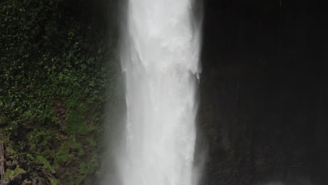 Slow-motion-shot-panning-up-large-jungle-waterfall-Costa-Rica-rainy-season