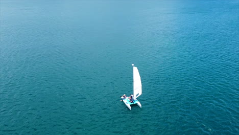 Eine-Luftaufnahme-Eines-Kleinen-Segelboots-Im-Blau-Der-Karibischen-Gewässer-An-Einem-Sonnigen-Tag