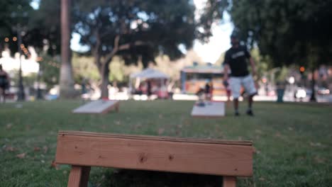Young-male-playing-cornhole-outside-at-the-park