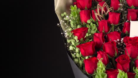 Rote-Rosen-Anordnung-Blumenstrauss-Anordnung-Mit-Karte-Schieber-Erschossen-Schwarzem-Hintergrund