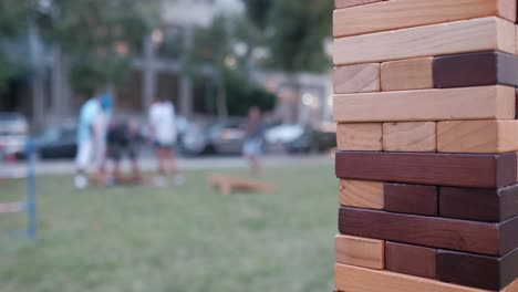 Jenga-close-up-with-people-in-background-playing-cornhole