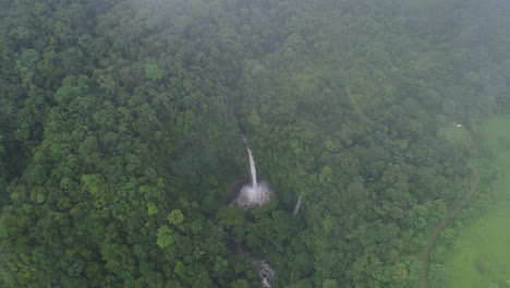 Aerial-over-lush-fog-covered-La-Fortuna-waterfall-costa-rica-rain-forest,-4K